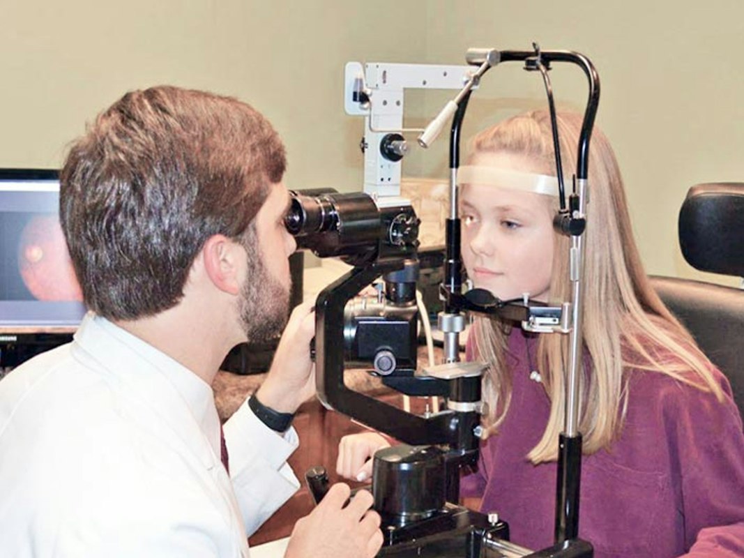Person examining their eyes in mirror